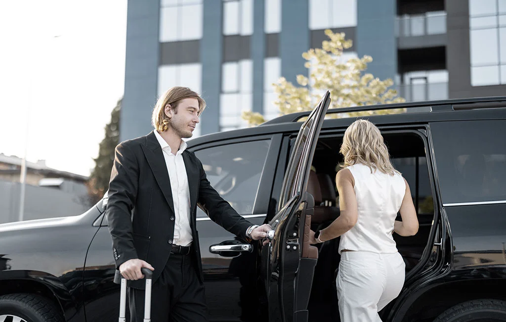 Business couple getting into an airport car service vehicle