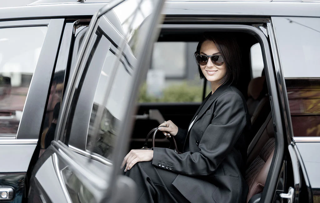 Business lady getting out of airport limousine