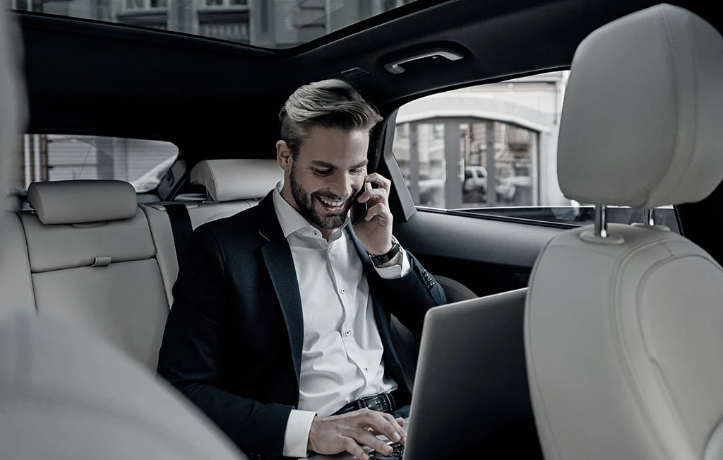 Businessman talking on phone onboard an airport car service vehicle