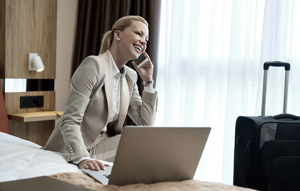 Businesswoman at hotel room talking on mobile phone