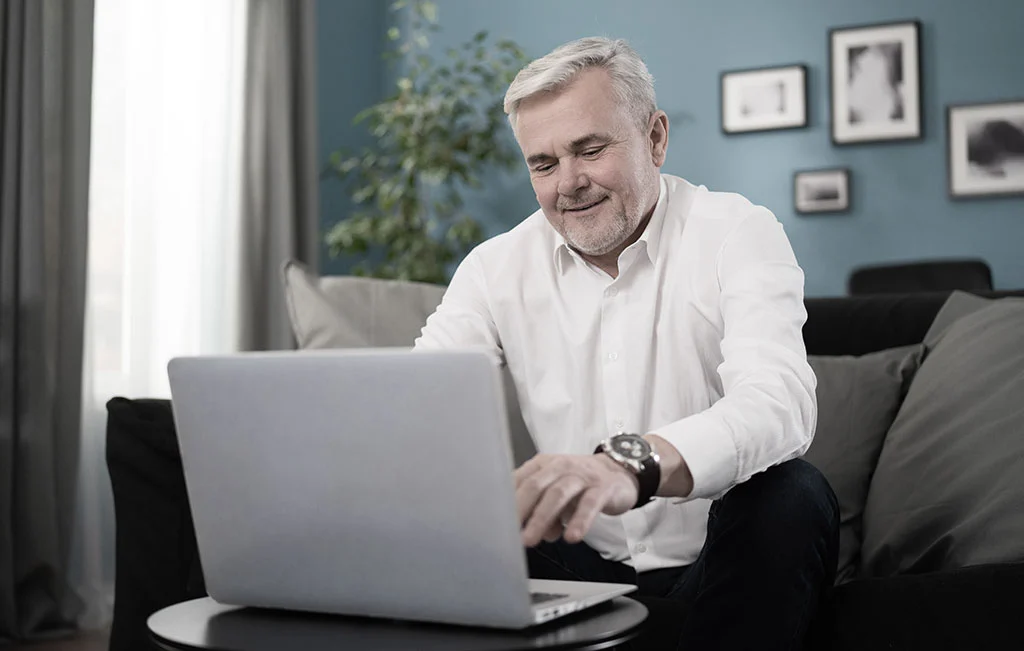 Middle-aged man working on laptop booking a private cruise transfer