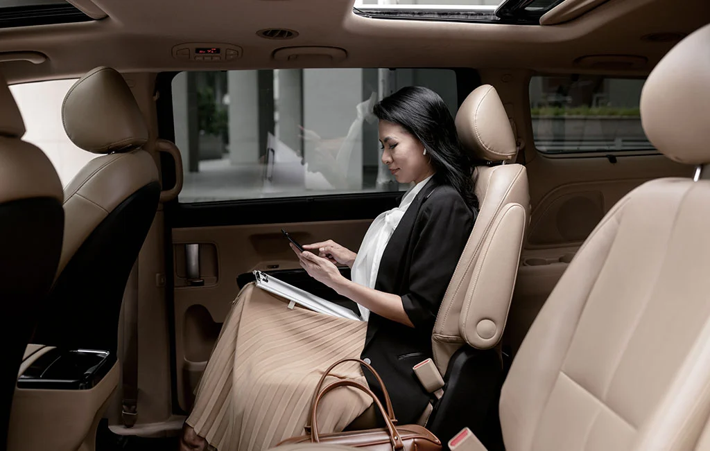Woman relaxing in the passenger seat of a limo service