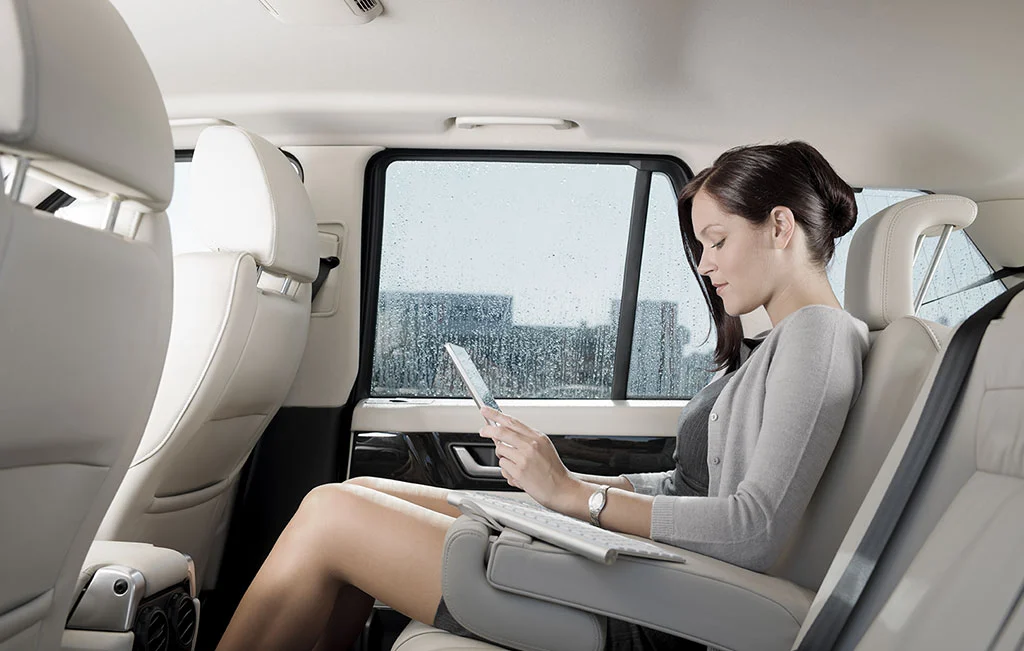 Young woman working inside limo using chauffeur service